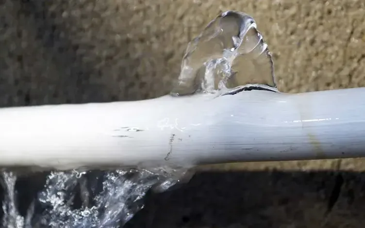 Water spraying from a split plastic supply pipe before the shutoff is closed