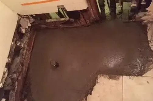 Opened and patched concrete slab under tile flooring after a slab leak